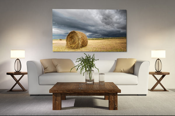 Canvas print of hay bale in a field hanging on a wall in rustic living room.