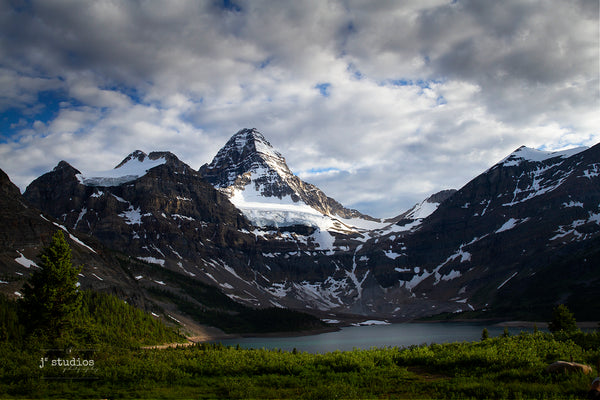 Beautiful stunning moody dramatic art print of Mount Assiniboine in Canadian Rockies towering over Lake Magog under layers of clouds. Matterhorn photography by Larry Jang.
