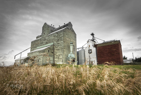 Standing in Three Hills is an art print of a pair grain elevators in Central Alberta. Heritage Photography.