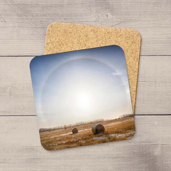 Square coaster with a prairie hay bale landscape, glossy finish, and non-slip cork base on a wooden surface.