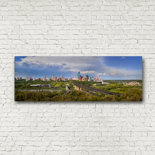 A panoramic canvas wall art print of Edmonton skyline with high level, walterdale, tawatina, low level bridge and dudley menzies bridge mounted on a white brick wall.
