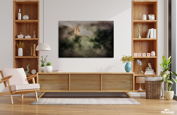 Canvas print of a Roussanou Byzantine monastery on a misty Greek cliff hanging above a white sofa in a modern living room.