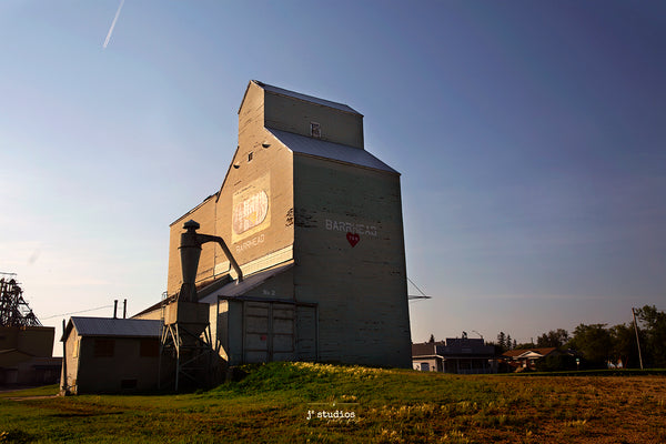 Picture of the sun setting on the Grain Elevator in Barrhead.  Prairie Sentinel Photography by Larry Jang of J² Studios.