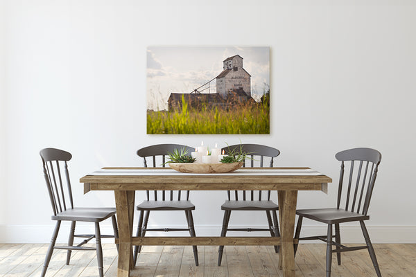 Grain elevator canvas print hanging on wall of rustic dining room.