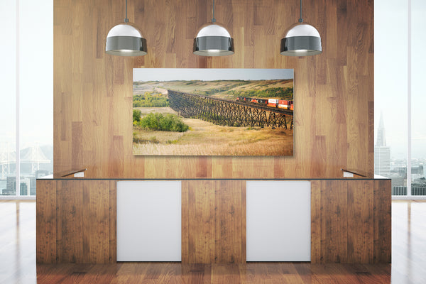 Big poster print of a train crossing a bridge on display in a modern office. 