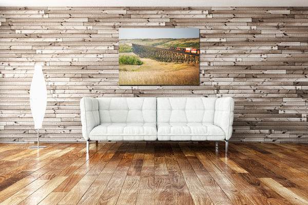 Canvas print of CN train crossing train bridge on display in modern living room.