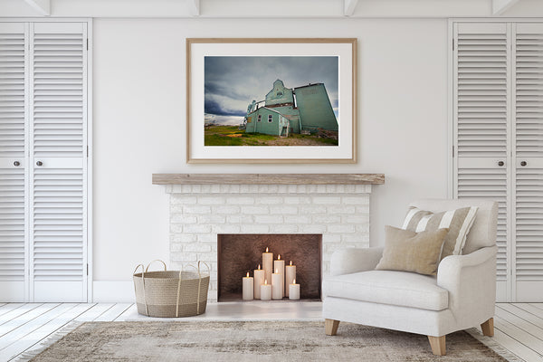 Framed print of Fort Macleod grain elevator on display above fireplace mantle in a living room of modern home.  Wall decor ideas. for cozy rooms 