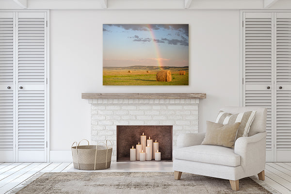 Prairie themed canvas print of hay bales & rainbow colors in living room with a fireplace.