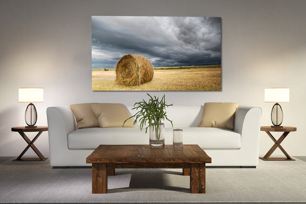 Canvas print of hay bale in a field hanging on a wall in rustic living room. 