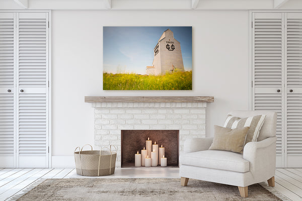 Canvas Print of Kinuso grain elevator hanging on wall of living room with a fireplace.