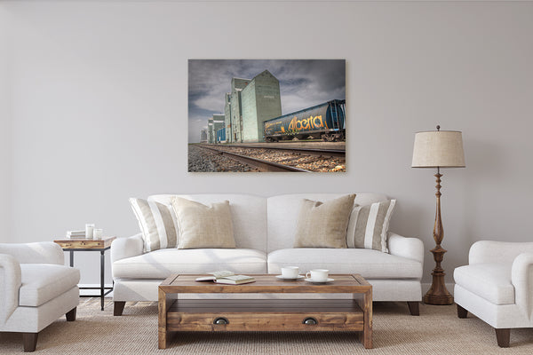 Stunning canvas print of grain elevators & Alberta hopper train car on display in rustic modern living room.