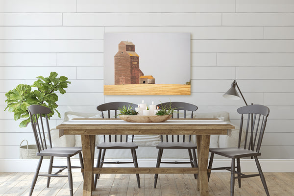 Canvas print of harvested wheat field hanging in rustic modern dining room.