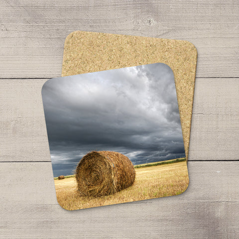 Coasters set of a Hay Bale sitting in farmers field awaiting an incoming storm in Pincher Creek, Alberta by Larry Jang.