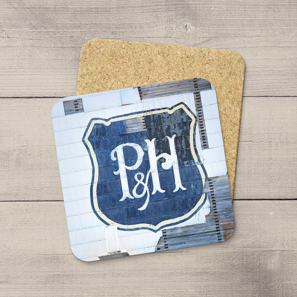 Photo of vintage P&H logo taken from the side of a grain elevator printed on drink coasters. Home accessories by Larry Jang
