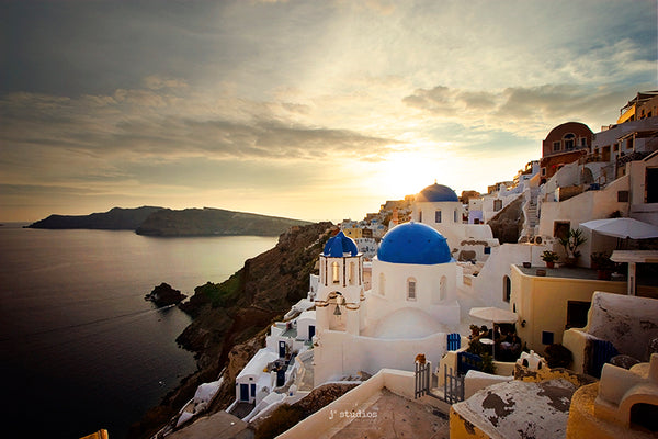 Photograph of the Village of Oia in Island of Santorini, Greece at sunset featuring Saint Spyridon Church And Anastasis Church famous blue domed churches. Travels as excellent art prints by Larry Jang and J2 Studios Photography.