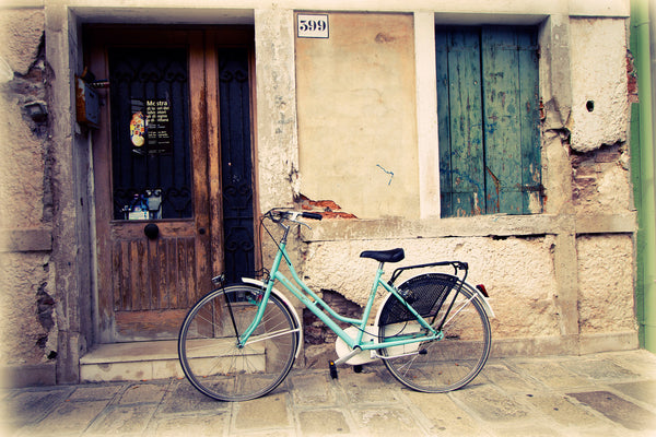 Aquamarine Bicycle is an art print of a bike parked in Burano, Italy.