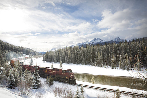 Around the Bend is an art print of a CP Rail Cargo train roaring through the snow capped peaks of Bannf National Park. Alberta Rocky Mountain Photography.