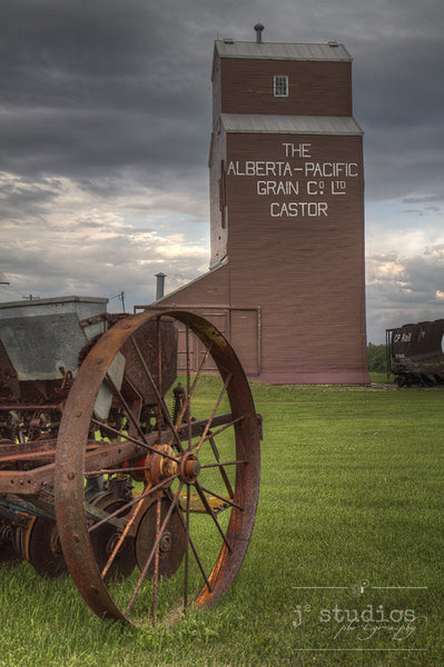 Picture of Alberta Pacific Grain Elevator in Castor with Vintage Farm Equipment and CP Rail Hopper car.