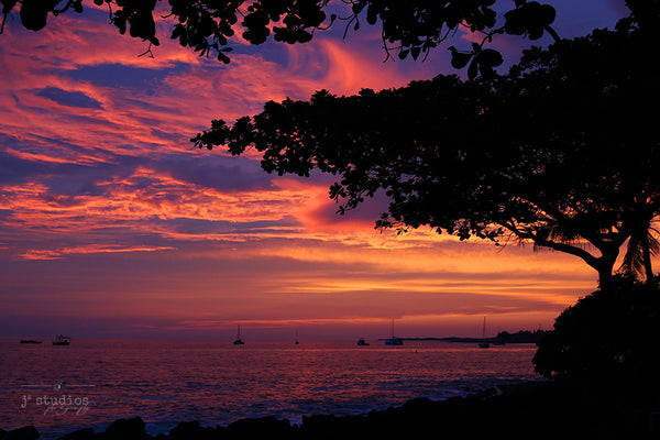 Crimson Skies is an art print of the setting sun over the Pacific Ocean on the Big Island of Hawaii.