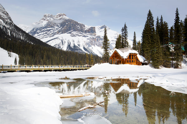 Image of the pristine and romantic Emerald Lake Lodge on the frozen shores of Emerald Lake. President's Peak looms in background. Best Canadian Rockies photography by Larry Jang. 
