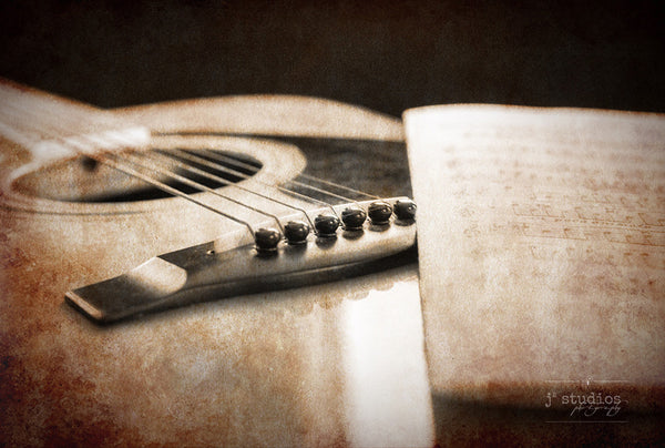 Guitar acoustics is an vintage sepia themed art print of an acoustic guitar and its sheet music.