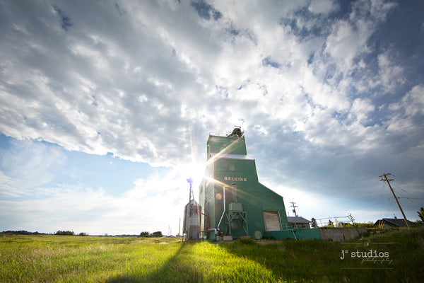 Wanderlust inspired summer themed image of the Alberta Wheat Pool grain elevator located in the village of Halkirk in Central Alberta. Rural Photography by J² Studios.
