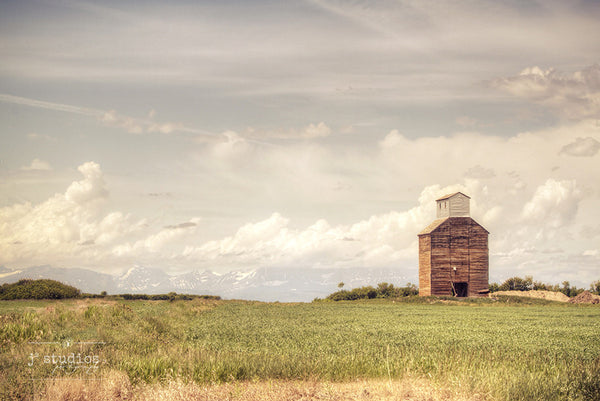 It Stood Weathered Against the Mountains is a sentimental inspired art print of a grain elevator with Glacier National Park in the background. Montana Photography.