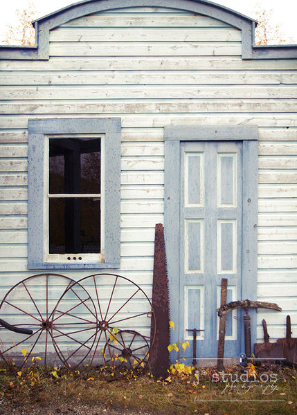 Klondike Blue is an art print of a door and various mining tools in Yukon Territory, Canada. 