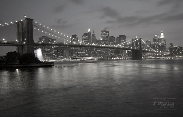 Manhattan at Night is a black and white art print of the iconic New York City skyline and the Brooklyn Bridge.