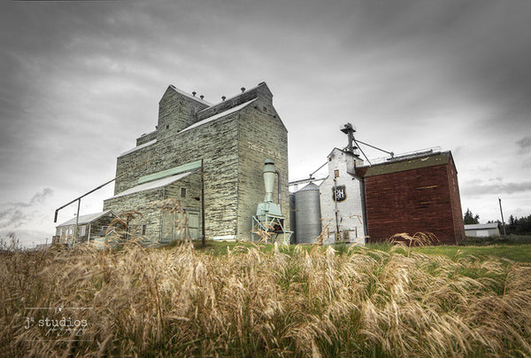 Standing in Three Hills is an art print of a pair grain elevators in Central Alberta. Heritage Photography.