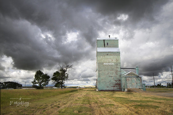 Art print of an approaching storm by the grain elevator in Magrath, Alberta. Canadian Prairies photography.