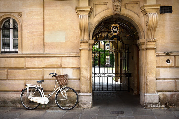 European themed image of a white ladies bicycle parked against the wall at Cambridge University in UK. Bike photography.